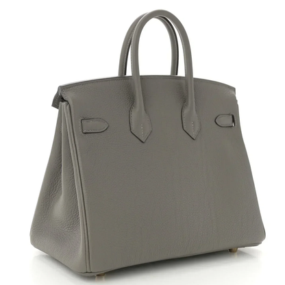Muted Ash Grey Natural Grain Compact Structured Trapezoid Tote With Glossy Warm Golden Twist Lock Hardware And Tonal Suspended Metal Padlock Charm